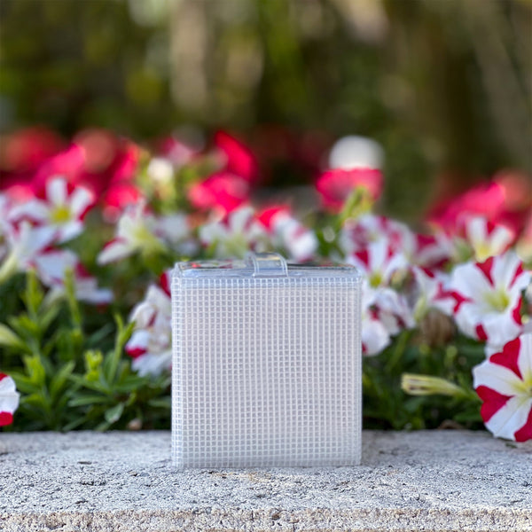 Genesis Mini Solar Lantern in flower garden with red and white flowers